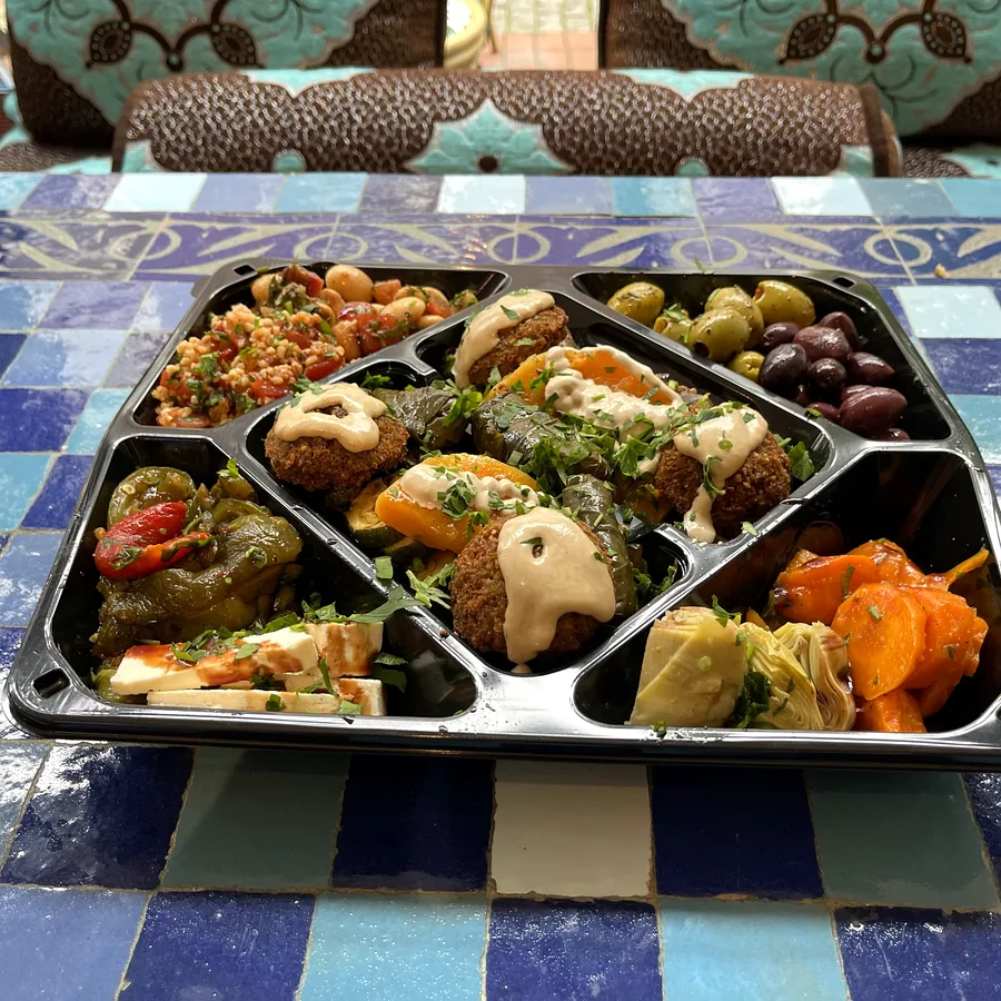 Mezze-Box zum Mitnehmen mit Falafel, Oliven, Tabouleh, gefüllten Weinblättern und Gemüse